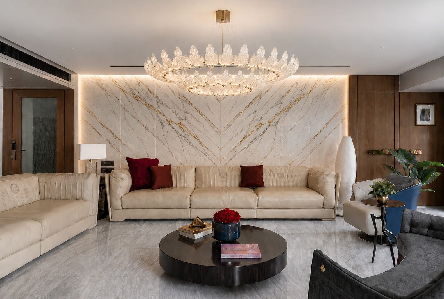 Aniket Apartment living room with marble feature wall, custom seating and statement chandelier